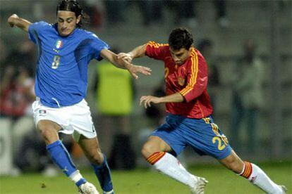 El italiano Alberto Aquilani (i) es perseguido por el español Javier Flanoi durante el partido de ida de la eliminatoria que enfrentó a ambas selecciones