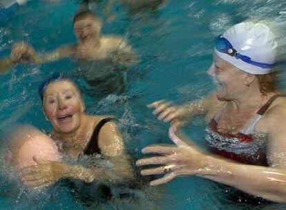 Un grupo de jubilados juega a la pelota en una piscina en Barcelona.