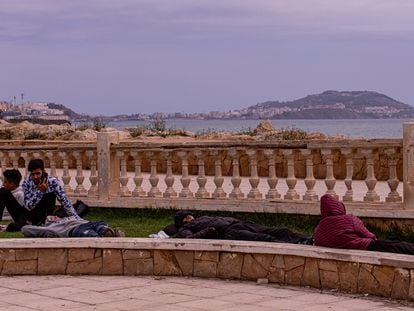 Varios Jóvenes descansan en un jardín próximo al paseo marítimo de la ciudad de Castillejos (Fnideq en árabe), en Marruecos. Al fondo se observa la ciudad de Ceuta.