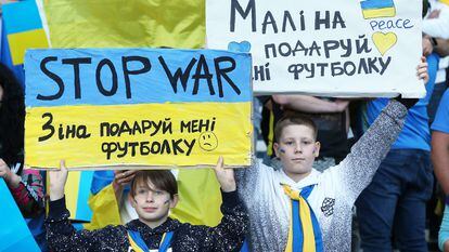 Dos niños ucranios piden la paz durante un partido de clasificación de su selección para el Mundial, el 1 de junio en Glasgow (Escocia).