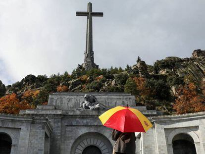 Una mujer sostiene un paraguas con los colores de la bandera de España en el Valle de los Caídos. En vídeo, las declaraciones del Secretario General de la Conferencia Episcopal sobre el apoyo de la Iglesia a la exhumación de Franco en una entrevista hoy en COPE.