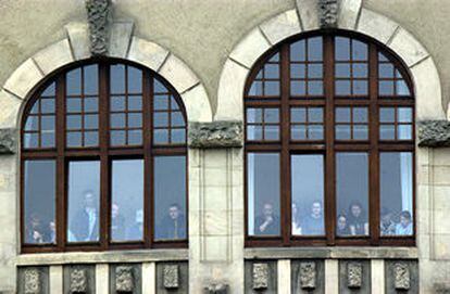 Varios alumnos, que quedaron encerrados en el instituto de Erfurt durante el tiroteo, observan a través de las ventanas.