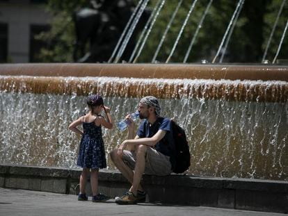 Vecinos refrescándose ante una fuente en el tercer día de la ola de calor, en Barcelona, esta semana.