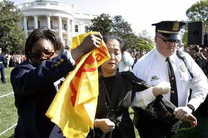 Detención de una manifestante por gritar durante la ceremonia de bienvenida a Hu Jintao en la Casa Blanca.