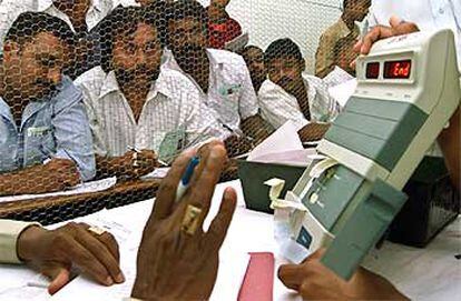 Interventores de los partidos miran una máquina electrónica de recuento de votos en la ciudad sureña de Bangalore.