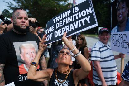 Un manifestante anti-Trump sostiene un cartel cerca de la entrada de la cárcel del condado de Fulton.