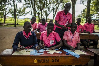 Denish supervisa el trabajo de sus compañeros en el taller de confección de compresas. Una vez termina la lección, todos estamparán su nombre con rotulador en la tela exterior del apósito y las chicas se quedarán con al menos dos compresas para ir alternándolas cuando les llegue el periodo. De media, una compresa hecha a mano les dura seis meses, es decir, seis menstruaciones. Proyectos similares se han puesto en marcha este año en 50 escuelas ugandesas, con apoyo de Unicef y, en el caso de Adjumani, gestionados por la ONG local Straight Talk.