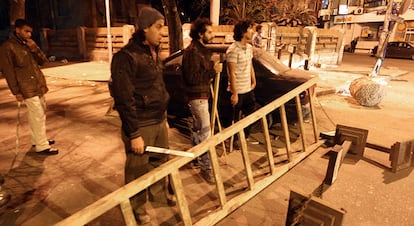 Jóvenes egipcios con palos y bastones bloquean una calle de El Cairo para proteger su propiedad ante los saqueadores