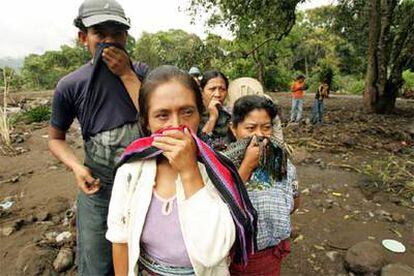 Un grupo de mayas guatemaltecos se cubren el rostro ante el hedor en Panabaj.