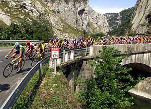 El pelotón atraviesa un puente en el transcurso de la etapa Cangas de Onís-Torrelavega.