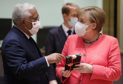 Angela Merkel sostiene un regalo de Antonio Costa