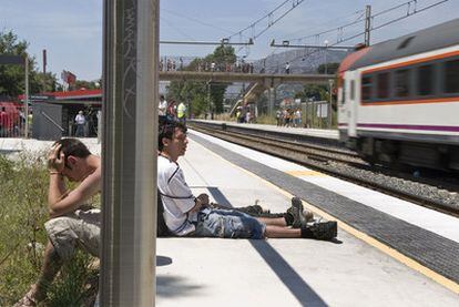 Unos jóvenes, sentados ayer en el anden de la estación de tren barcelonesa.