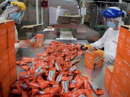 Dos empleadas empaquetan Conguitos en la fábrica de Lacasa en Zaragoza.