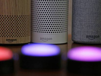 FILE - In this Sept. 27, 2017, file photo, Amazon Echo and Echo Plus devices, behind, sit near illuminated Echo Button devices during an event announcing several new Amazon products by the company in Seattle. Amazon is expanding its home-security business by buying Ring, the maker of Wi-Fi-connected doorbells. The deal comes months after the online retailer started selling its own Wi-Fi-connected indoor security cameras, which work with its voice-assistant Alexa. (AP Photo/Elaine Thompson, File)