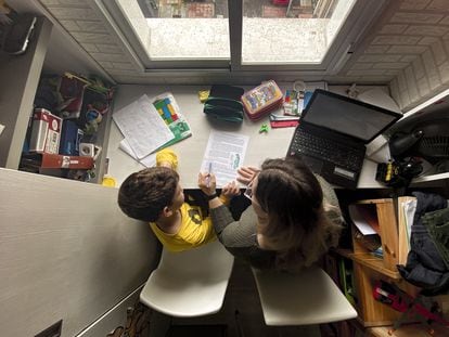 Un niño estudia con su madre en su casa en Madrid.