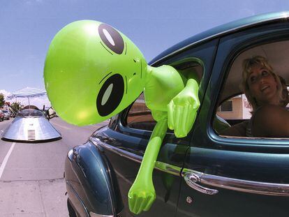 Un muñeco alienígena cuelga de la ventana de un automóvil en el centro de Roswell, Nuevo México, el 1 de julio de 2000 como parte del Festival OVNI anual.