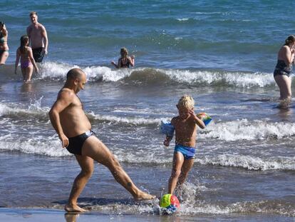 Un hombre juega con un ni&ntilde;o en una playa de Gran Canaria. 