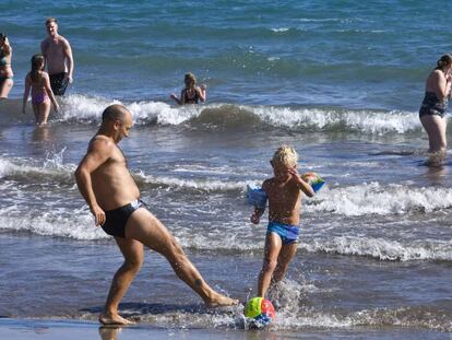 Un hombre juega con un niño en una playa de Gran Canaria. 