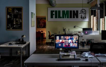 La segunda planta de la sede de Filmin en Barcelona, con una pantalla en la que se ve a sus empleados teletrabajando.