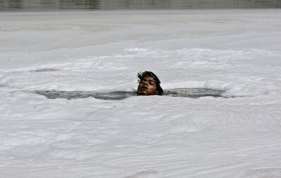 Un ciudadano indio toma aire mientras bucea en un contaminado río Yamuna, en Nueva Delhi (India), en busca de adornos y monedas que podrían haber quedado bajo el agua tras un ritual hindú en la orilla del río. Funcionarios denuncian que las empresas ignoran la legislación para la protección del medio ambiente, contaminando un río que abastece de agua a buena parte de la capital india. Según la ONU, cada año se arrojan a los lagos, ríos y deltas el equivalente al peso de la población mundial -cerca de 7.000 millones de personas- en forma de contaminación.