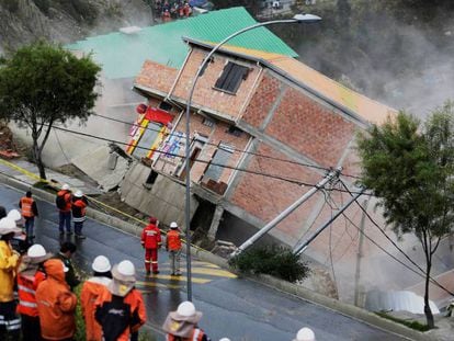 Miembros del equipo de rescate observan un edificio derruido en La Paz. En vídeo, el deslizamiento en la capital boliviana.