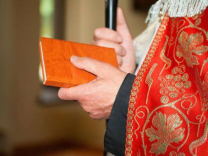 Un sacerdote porta una Biblia.