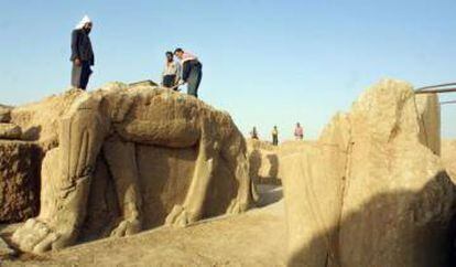 Trabajadores limpian una estatua en un yacimiento arqueológico en Nimrud.