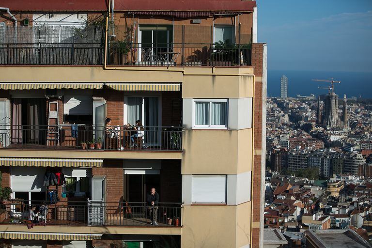 Los vecinos de este edificio de Barcelona se asoman a sus terrazas durante el confinamiento.