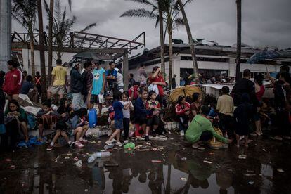 Cientos de personas en las cercanías del aeropuerto esperan para ser evacuados cinco días después del paso del tifón.