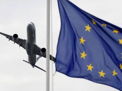 Un  Airbus vuela con una bandera de Europa en primer plano. 