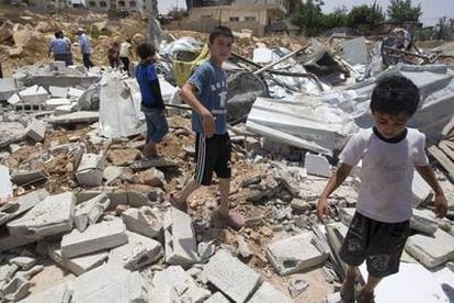 Niños palestinos caminan sobre los escombros de una de las casas destruidas por Israel en Jerusalén Este