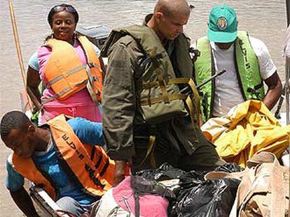 Un agente de la policía nacional de Colombia revisa los equipajes de unos pasajeros que navegan por el Atrato.
