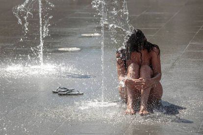 Una persona se refresca en una fuente del Parque Central de Valencia.