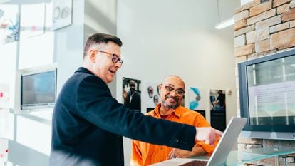 Dos profesionales de marketing, trabajando junto a un ordenador portátil.