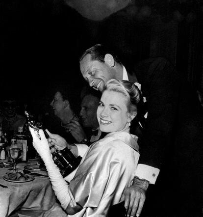 Grace Kelly sujeta un Oscar mientras es abrazada por William Holden en una fiesta post-Oscars en 1955.
