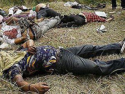 Varios policías forenses junto a varios cadáveres tras producirse la masacre en la provincia de Maguindanao.