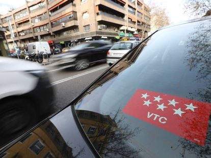 Un vehículo de transporte con conductor circula por las calles de Madrid.