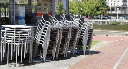 Sillas y mesas apiladas de un restaurante sin actividad en Bilbao.