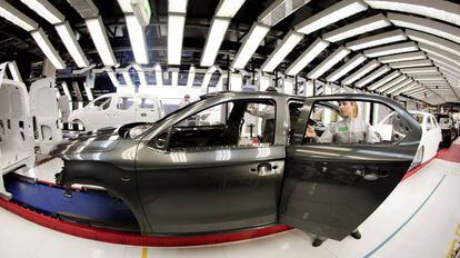 Una trabajadora revisa el arco de luces de un veh&iacute;culo en una planta de PSA (Peugeot Citro&euml;n) de Vigo. 