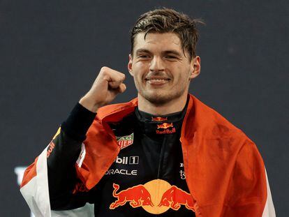 2021 FIA Formula One World Champion Red Bull's Dutch driver Max Verstappen celebrates on the podium of the Yas Marina Circuit after the Abu Dhabi Formula One Grand Prix on December 12, 2021. - Max Verstappen became the first Dutchman ever to win the Formula One world championship title when he won a dramatic season-ending Abu Dhabi Grand Prix. (Photo by KAMRAN JEBREILI / POOL / AFP)