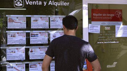 Un hombre mira el escaparate de una inmobiliaria en Madrid. 