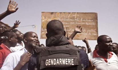 Un miembro de la polic&iacute;a de Burkina Faso corta el acceso de la gente al cementerio donde se lleva a cabo la exhumaci&oacute;n.