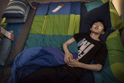 Un joven duerme en una de las camas de la exposición de Ikea en Pekín.