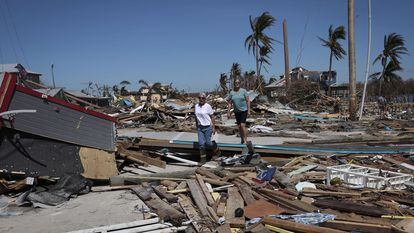 Dos mujeres caminan entre los destrozos ocasionados por el huracán Ian, este viernes en la isla de Matlacha, en Florida.