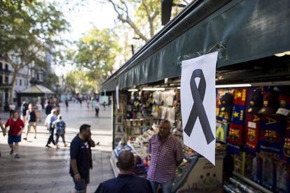 Un lazo negro cuelga de uno de los kioskos de las Ramblas de Barcelona tras el atentado del jueves. 