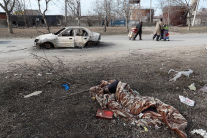 Un cadáver cubierto por una manta en una calle de Mariupol, este domingo. 