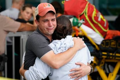 Una pareja se abraza tras el colapso del edificio en Surfside.