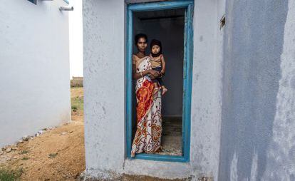 Una mujer y su bebé posan junto a su nueva letrina en Anantapur, India.