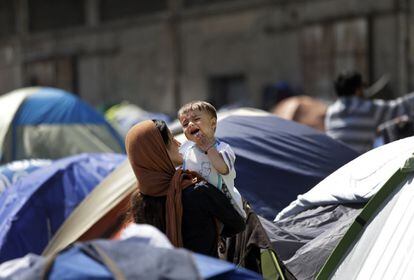 Una migrante sujeta a un beb&eacute; este mi&eacute;rcoles en el puerto del Pireo.