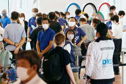 Funcionarios del comité organizador de Tokio 2020 reciben a atletas extranjeros en el aeropuerto de Haneda, en la capital japonesa, este jueves